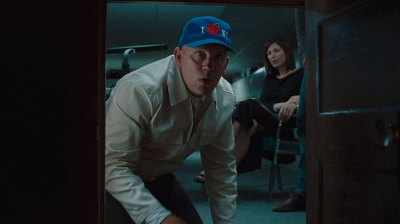 John Malkovich peeks into a tiny door that goes into his head as Maxine Lund (Catherine Keener) looks on in Being John Malkovich