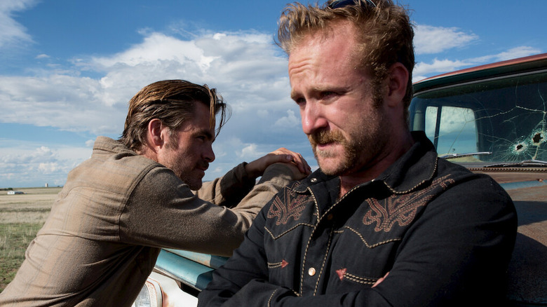 Chris Pine as Toby and Ben Foster as Tanner leaning against a truck in Hell or High Water