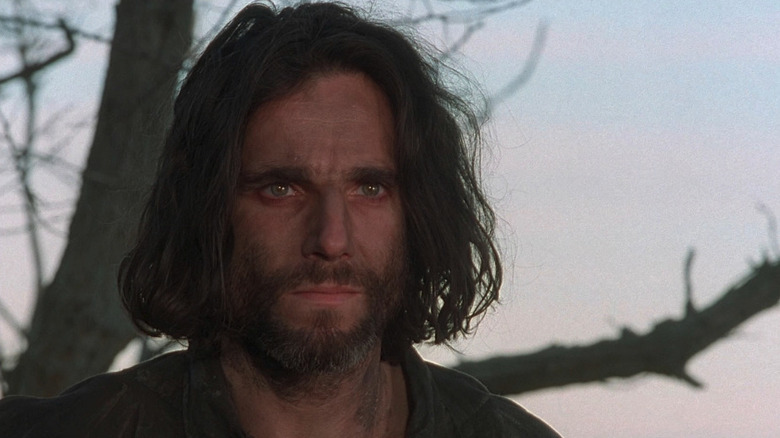 A weathered John Proctor (Daniel Day-Lewis) stands by a tree in The Crucible (1996)