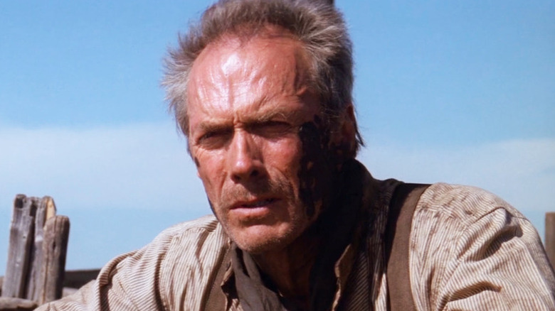 Will Munny (Clint Eastwood) leans over a fence in Unforgiven (1992)