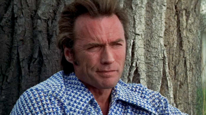Clint Eastwood's Thunderbolt looks off into the distance as he leans against a tree in Thunderbolt and Lightfoot