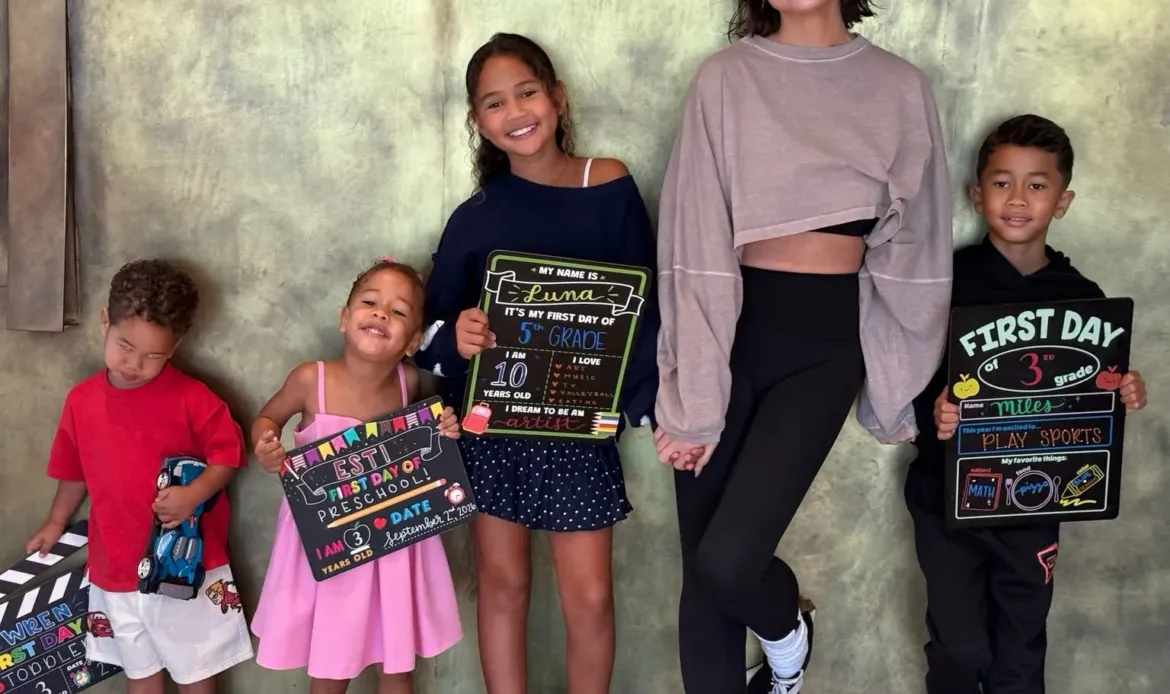Chrissy Teigen and her four children pose with "First Day of School" signs.