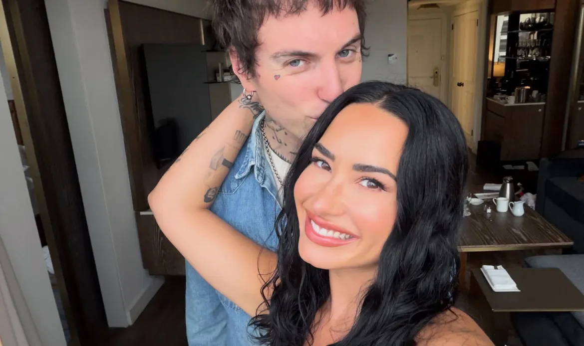 Demi Lovato taking a selfie with Jordan Lutes kissing her on the cheek.