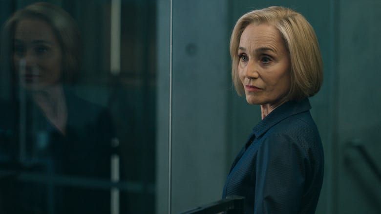 Kristin Scott Thomas' Diana Taverner stands by a large pane of glass in Slow Horses