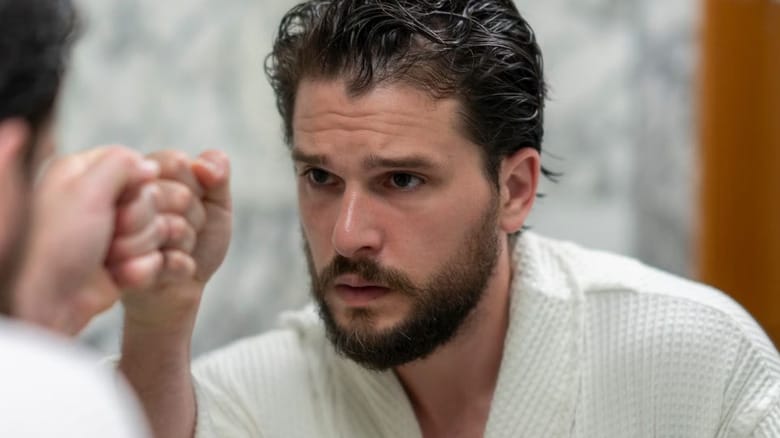 Kit Harington as Sir Henry Muck in Industry, touching his fist to a mirror, wearing a robe.