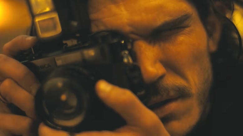 Fra Fee snapping a photo with his camera in The Last Photgraph
