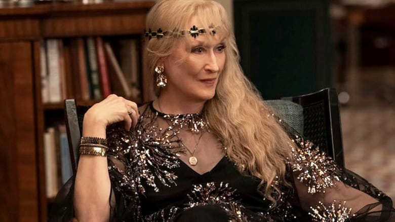 Loretta wearing ostentatious clothing and sitting in a chair in Only Murders in the Building