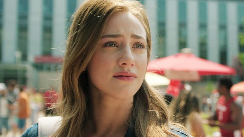 Lili Reinhart's Olive Smith looks off into the distance as she stands outside on a college campus in The Love Hypothesis