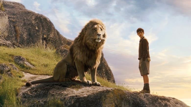 Aslan standing next to young Edmund on a rocky surface in The Lion The Witch and the Wardrobe