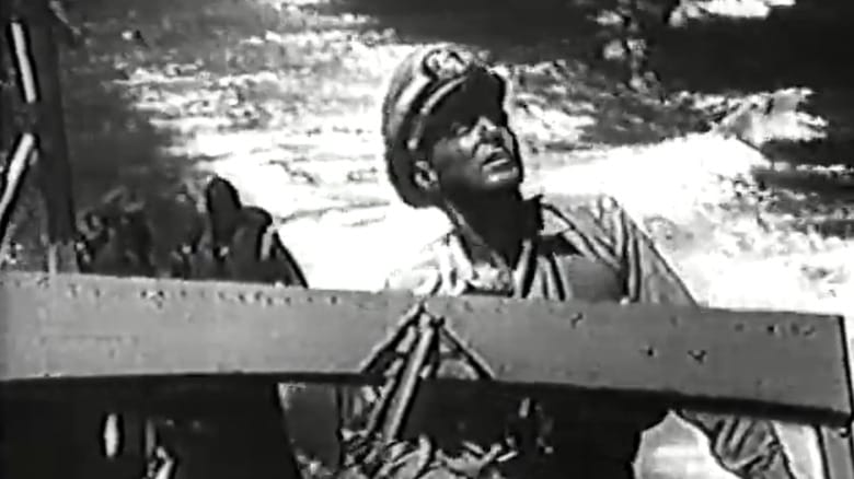 John Baer's John F Kennedy stands at the helm of a boat in Navy Log