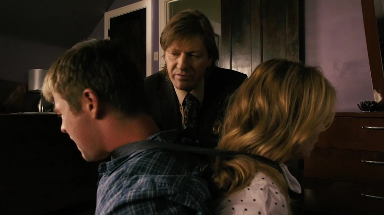 Sean Bean as Pyke Kubic looking at Chris Hemsworth as Sam and Victoria Profeta as Leslie tied to a chair in Ca$h