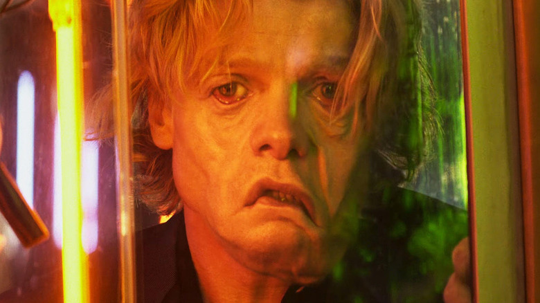 Tom Rhys Harries as Matt Hagen looking at the reflection of his face melting in Clayface