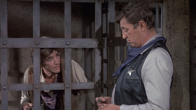 Robert Mitchum's Deputy Ben Kane stands by a jail cell holding Robert Walker Jr's Billy Young in Young Billy Young.jpg