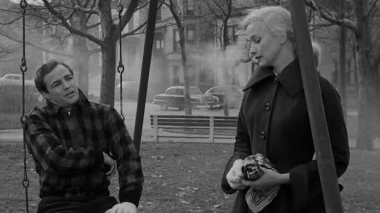 Marlon Brando as Terry Malloy sits on a swing and shares a moment with Eva Marie Saint as Edie Doyle in On the Waterfront