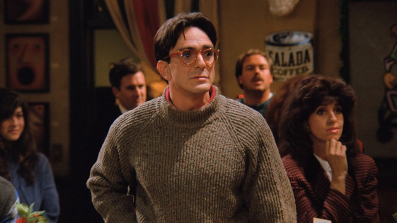 Hank Azaria's David stands in a coffee house in Friends