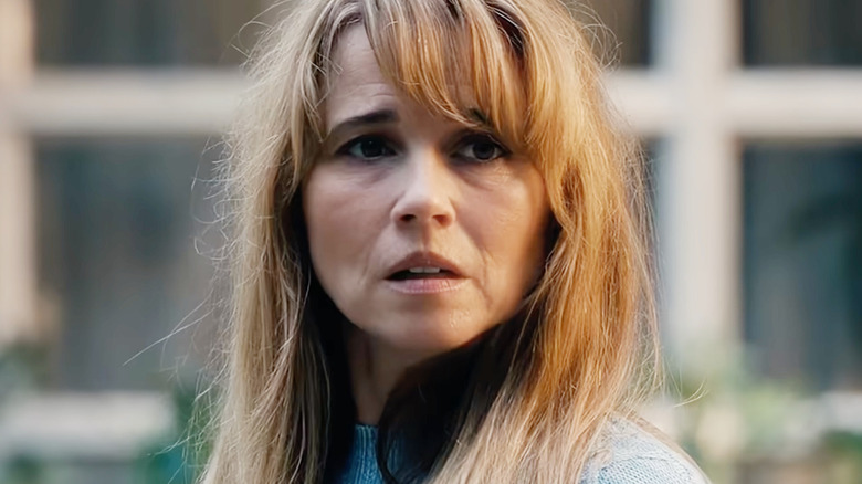 Linda Cardellini as Pamela Voorhees looking distressed in a blue sweater in Crystal Lake