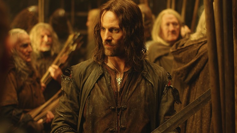 Viggo Mortensen as Aragron holding his sword as people arm themselves in The Lord of the Rings: The Two Towers