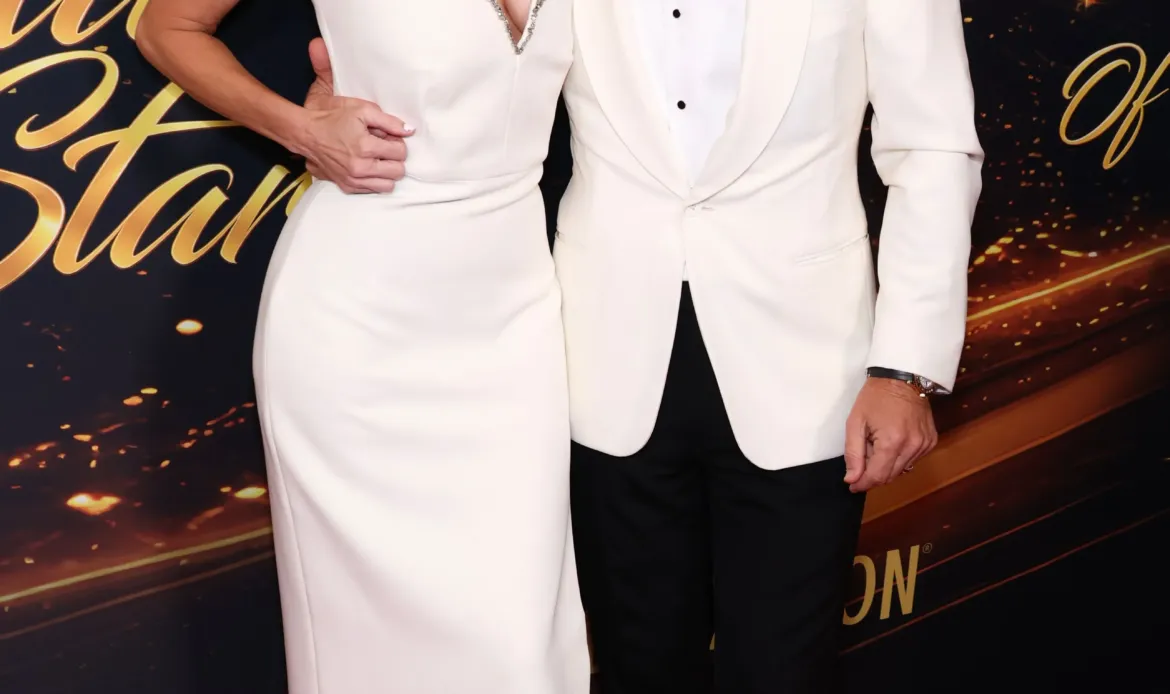 Kym Johnson Herjavec and Robert Herjavec posing together on the red carpet.