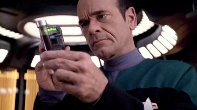 Robert Picardo as The Doctor inspecting a handheld device in an episode of Star Trek: Voyager