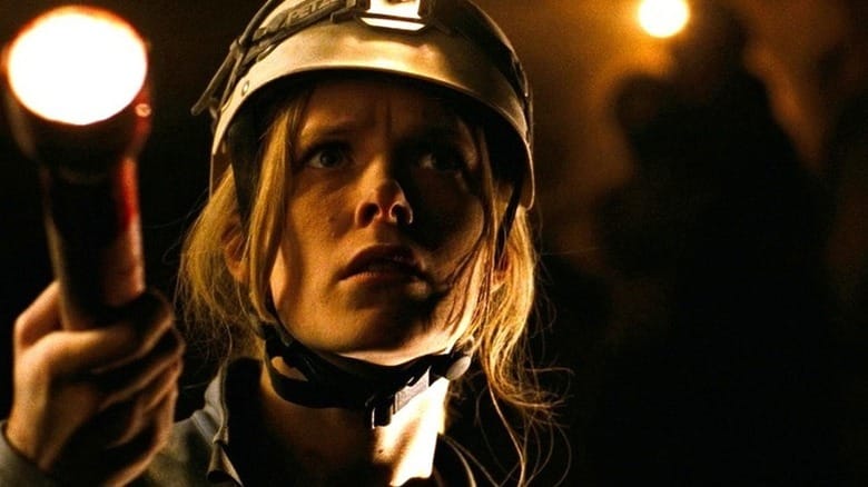 Sarah (Shauna Macdonald) shines a flashlight in a cave in The Descent