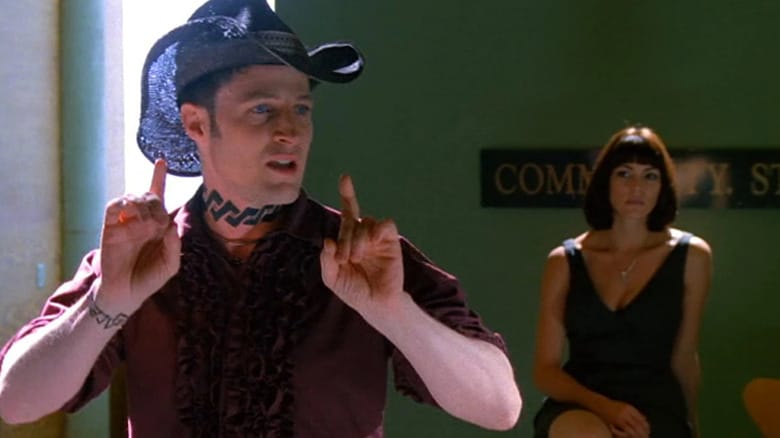 John in a cowboy hate in front of a slinky woman in Brave New World