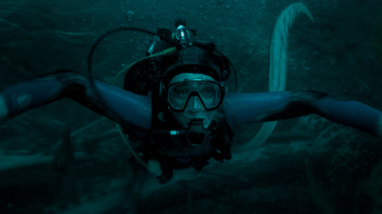 Austin Abrams as Jay Gardiner in scuba gear swimming away from a giant squid in Whalefall